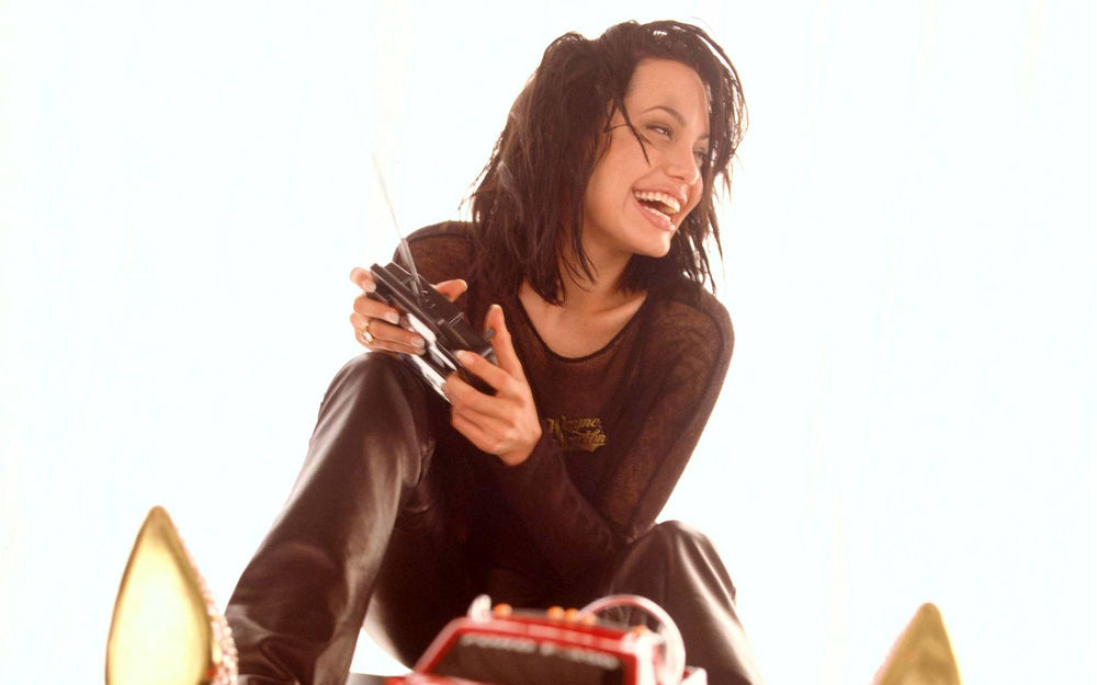 Обои для рабочего стола Angelina Jolie / Анджелина Джоли играется с радиоуправляемой красной машинкой