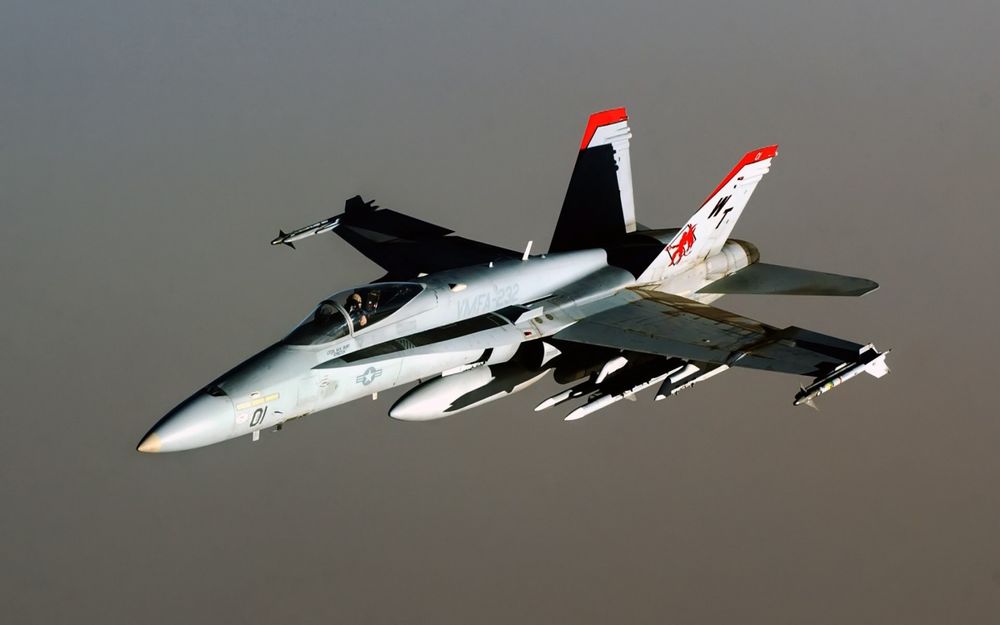 Обои для рабочего стола Сверхзвуковой истребитель-перехватчик F/A-18 Hornet совершает учебно-тренировочный полет с боевыми ракетами на внешних подвесках