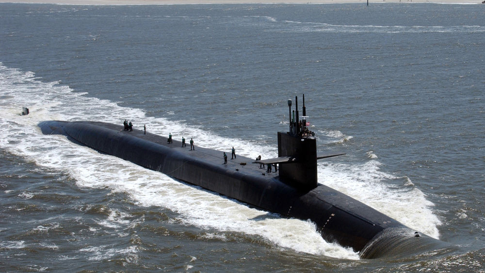 Обои для рабочего стола Атомная подводная лодка 'Флорида'Военно-морских сил США класса 'Огайо'выходит из морской базы на выполнение боевых задач, на верхней палубе часть экипажа выполняет работы по предстоящему погружению