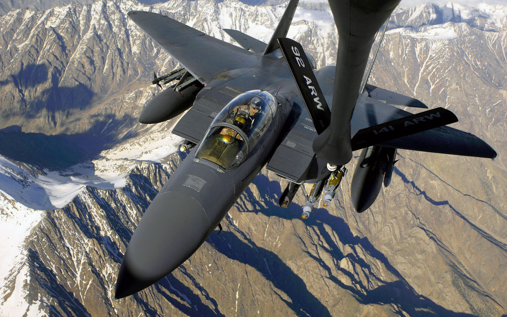 Обои для рабочего стола Истребитель F-15Е созданный корпорацией Mc Donnell Douglas,USA/Макдоннелл-Дуглас,США в полете над гористой местностью производит дозаправку топливом