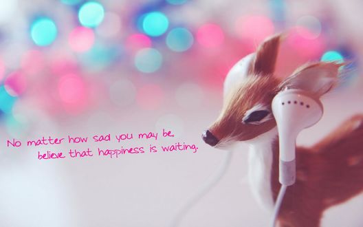 Обои на рабочий стол Игрушечный олень с наушниками возле ушей (No matter how sad you may be believe that happiness is waiting / Неважно насколько ты печален, поверь - счастье ждет)