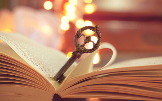 Обои на рабочий стол Красивый старинный ключ лежит на раскрытой книге