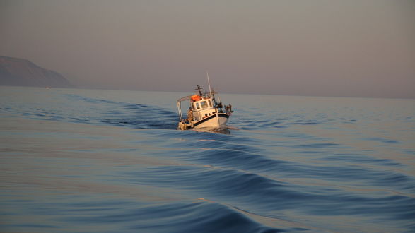 Обои на рабочий стол Небольшое рыбацкое судно выходит в открытое море
