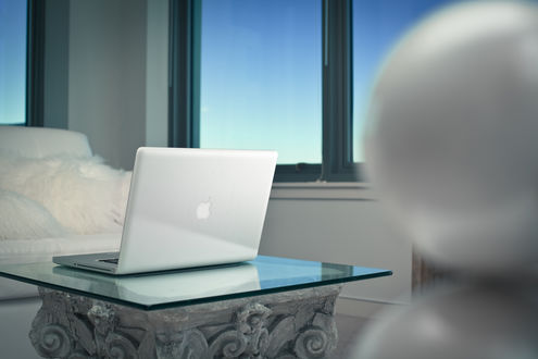 Обои на рабочий стол Белый ноутбук Apple MacBook Pro лежит на стеклянном столе, в светлой комнате