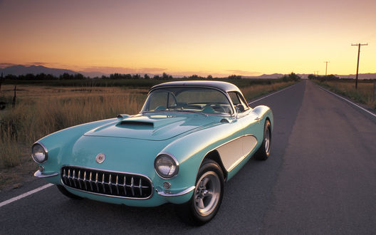 Обои на рабочий стол Автомобиль Корвет, США / Corvette, USA, 1957 года выпуска, на дороге, на линии горизонта виднеются горы и лес