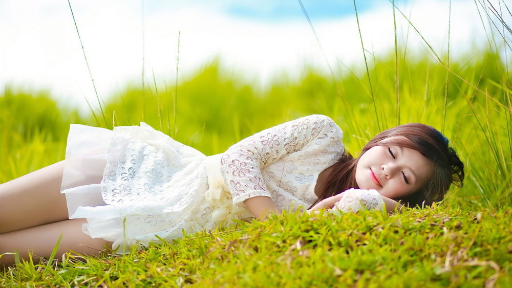 Обои для рабочего стола Лето, девушка в белом платье сладко уснула на зеленой траве