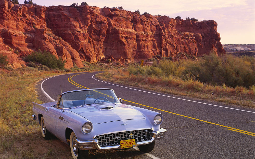 Обои для рабочего стола Автомобиль Форд Ти-Берд, США / Ford T-Bird, USA, 1957 года выпуска, припаркованный возле разноцветных скалистых утесов, на шоссе в штате Нью-Мексико, США / New Mexico, USA