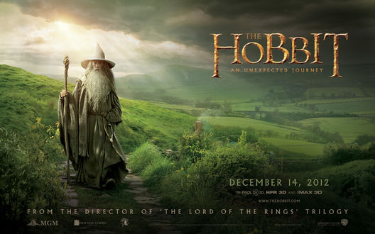 Обои на рабочий стол Gandalf / Гэндальф стоит на зелёной поляне на фоне гор, неба и облаков, из фильма Хобиит / Hobbit
