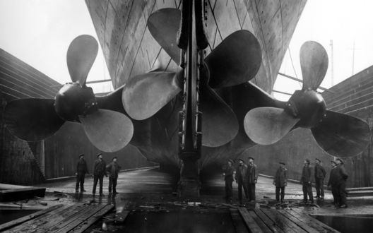 Обои на рабочий стол Рабочие смотрят на огромные винты Титаника / Titanic  на верфях судостроительной компании «Харленд энд Вольф» в Куинс-Айленд