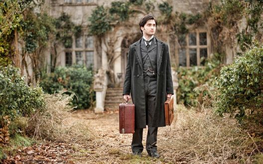 Обои на рабочий стол Дэниел Рэдклифф / Daniel Radcliffe, стоит с двумя чемоданами в руках, позади его дом