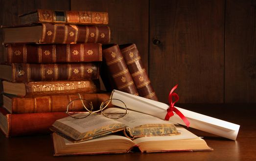 Обои на рабочий стол Старые книги на столе, на них лежат свёрнутый свиток и очки
