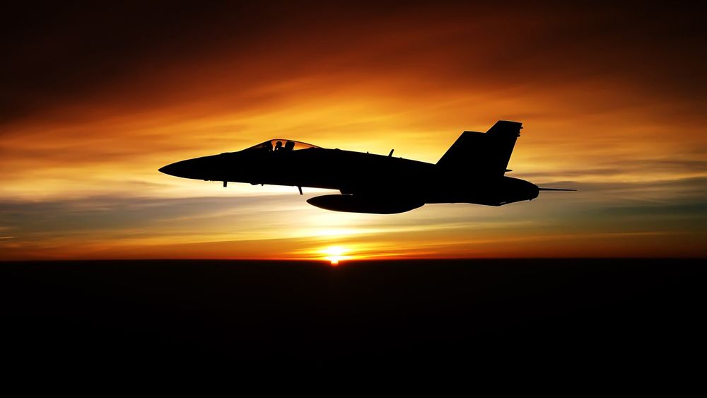 Обои для рабочего стола Силуэт американского истребителя FA-18F на фоне заката солнца