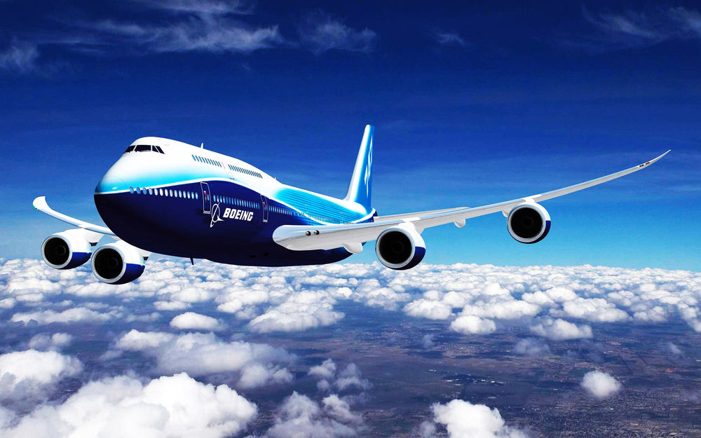 Обои для рабочего стола Самолет компании Boeing / Боинг летит над облаками