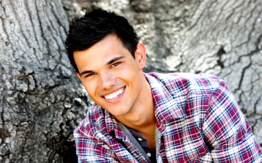 Обои на рабочий стол Американский актер Тейлор Лотнер / Taylor Lautner в клетчатой рубашке сидит около дерева