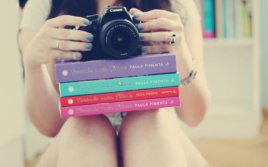 Обои на рабочий стол Девушка с книгами на коленях и фотоаппаратом в руках