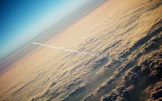 Обои на рабочий стол Инверсионный след самолета над облаками