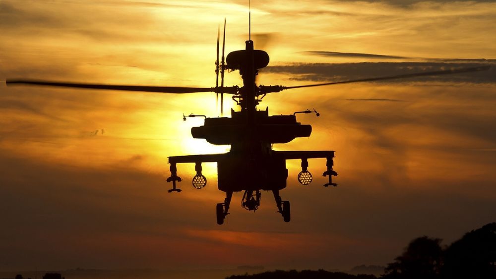Обои для рабочего стола Американский вертолет Ан-64 'Апач / Apache' совершает полет на фоне заката солнца