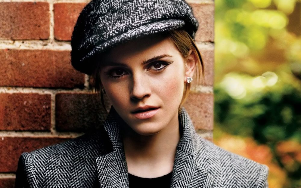 Обои для рабочего стола Британская киноактриса и фотомодель Эмма Уотсон / Emma Watson в пальто и берете стоит у стены