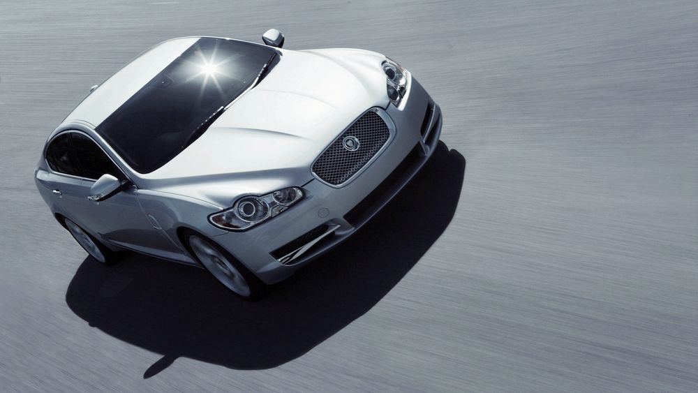 Обои для рабочего стола Светло-серый автомобиль Jaguar XF с бокового ракурса