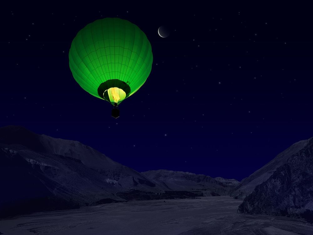 Обои для рабочего стола Ночной полет на зеленом воздушном шаре над покрытыми снегом горами