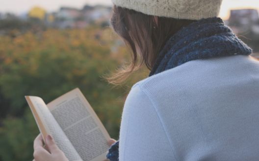 Обои на рабочий стол Девушка читает книгу на природе