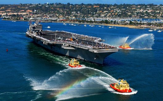 Обои на рабочий стол Джон К. Стеннис / USS John C. Stennis (CVN-74)) - американский авианосец, седьмой из серии класса Нимиц, в бухте среди катеров
