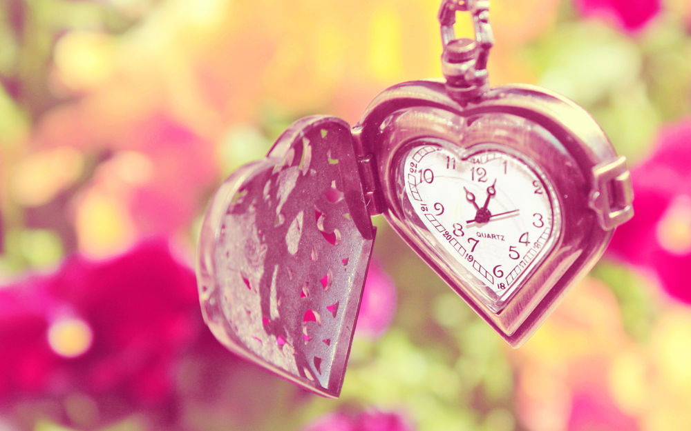 Обои для рабочего стола Часы в форме сердечка на фоне розовых цветов