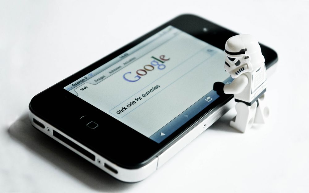 Обои для рабочего стола Фигурка имперского штурмовика, персонажа саги Звездные войны / Star Wars у черного телефона, в браузере которого открыт поисковик Google (dark side for dummies / темная сторона для чайников)