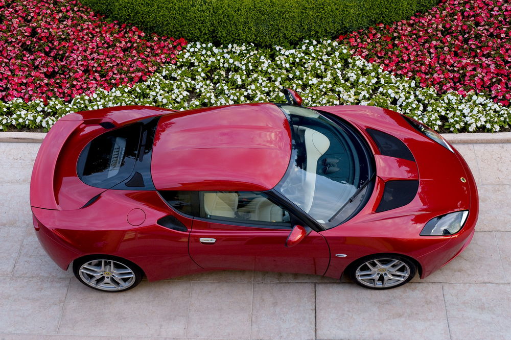 Обои для рабочего стола Lotus Evora / Лотус Эвора 2010 (Wine color Metallic), у цветочной клумбы