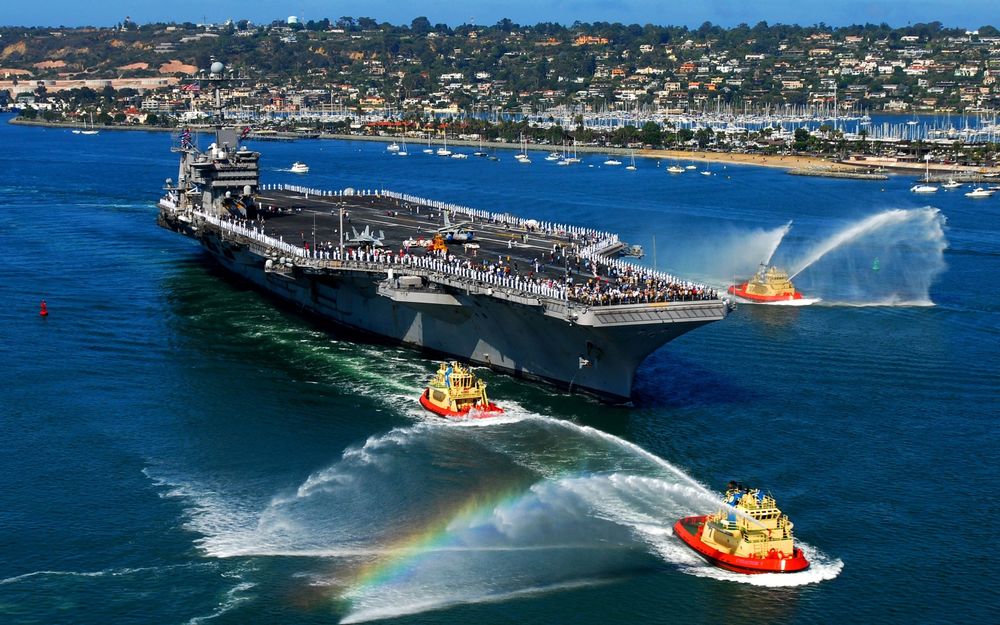 Обои для рабочего стола Джон К. Стеннис / USS John C. Stennis (CVN-74)) - американский авианосец, седьмой из серии класса Нимиц, в бухте среди катеров