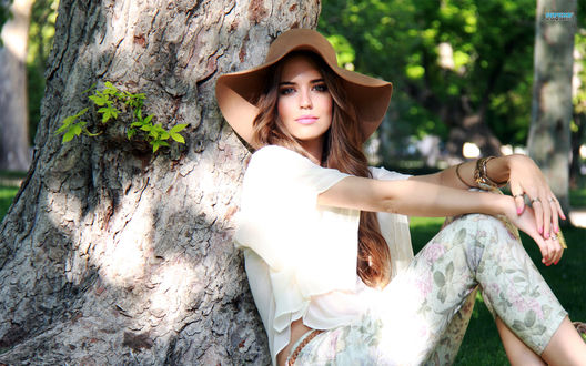 Обои на рабочий стол Модель Клара Алонсо / Clara Alonso в широкой шляпе сидит под деревом