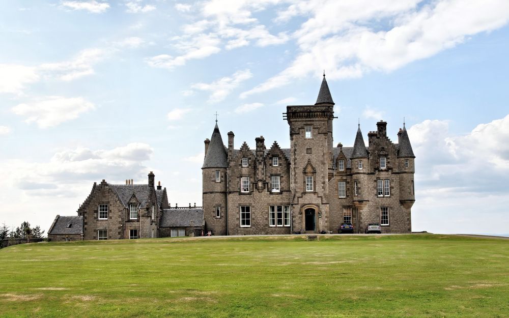 Обои для рабочего стола Glengorm Castle / замок Сон, Scotland / Шотландия на фоне зеленого поля и облачного неба