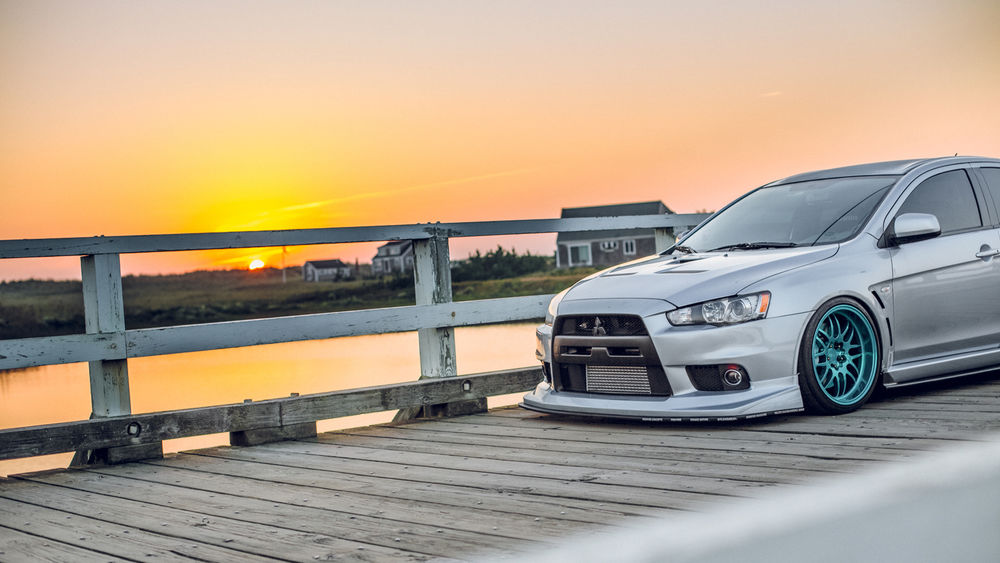 Обои для рабочего стола Белый автомобиль Mitsubishi Lancer Evolution / Мицубиси стоит на фоне заката солнца