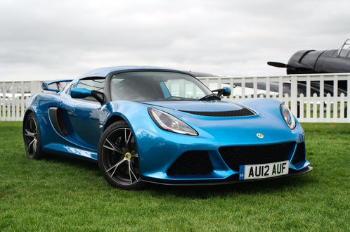Обои на рабочий стол Синяя машина марки Lotus Exige V6 стоит на зеленом газоне