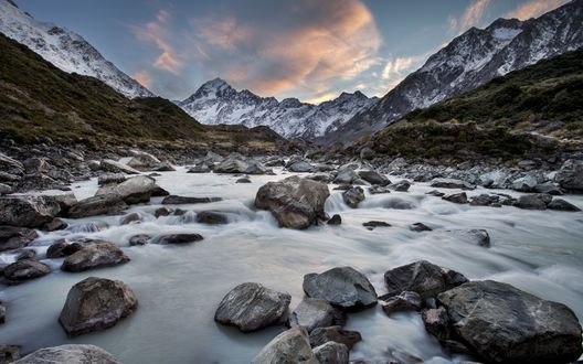 Обои на рабочий стол Камни на берегу реки на фоне гор, Новая Зеландия / New Zealand