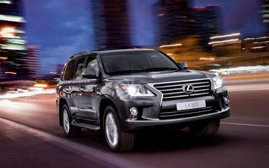 Обои на рабочий стол Черный автомобиль Lexus LX 570 / Лексус 570 едет по дороге, на фоне ночного города