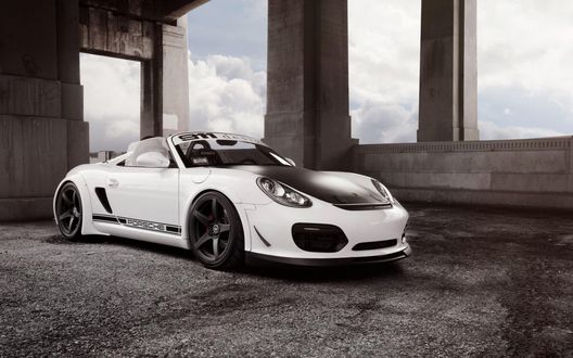 Обои на рабочий стол Белый автомобиль Porsche Boxster Spyder стоит в здании