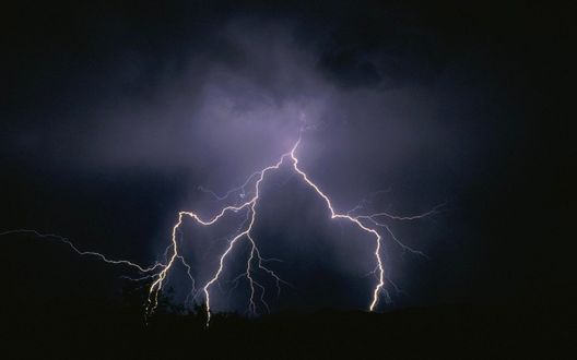 Обои на рабочий стол Разряды молний бьют в землю