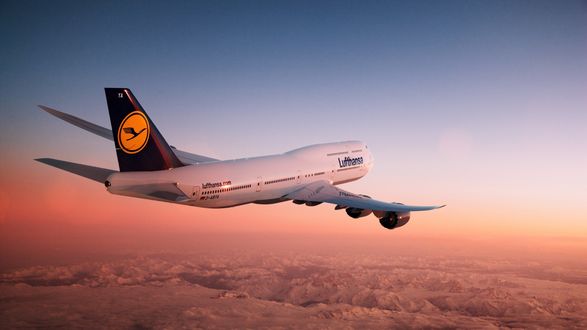 Обои на рабочий стол Самолет компании Lufthansa летит над снежными горами