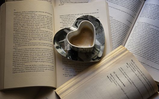 Обои на рабочий стол Чашка кофе в форме сердца стоит на страницах книги