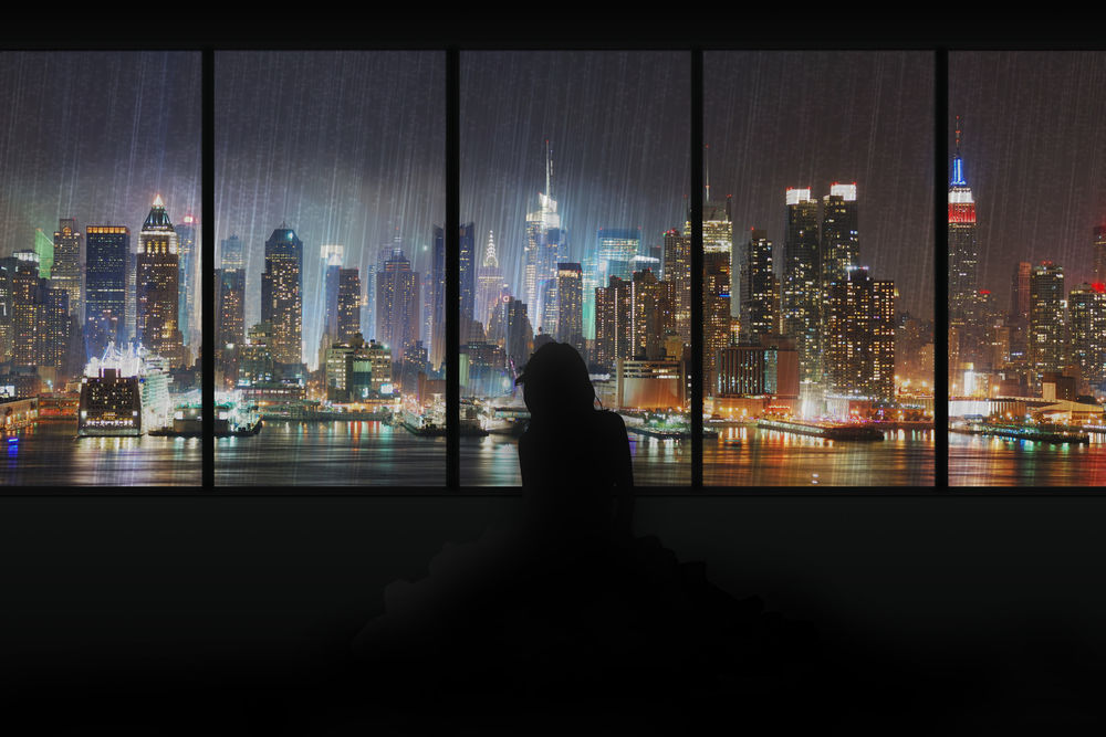 Обои для рабочего стола Силуэт девушки, которая смотрит в окно, на ночной город