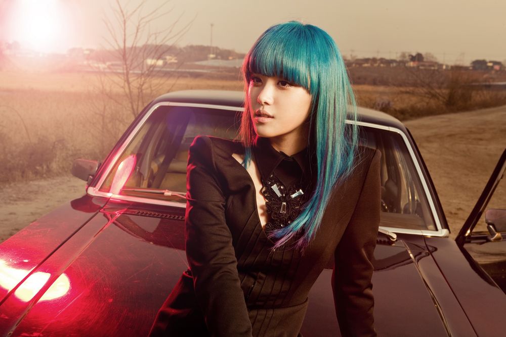 Обои для рабочего стола Южнокорейская певица и танцовщица Song Ji-Eun / Сон Джи Инь с голубыми волосами сидит на машине, кадр из клипа Going Crazy