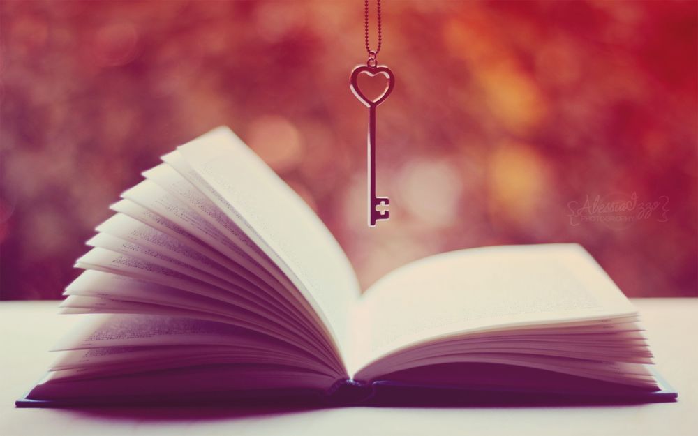 Обои для рабочего стола Ключ подвешен над раскрытой книгой