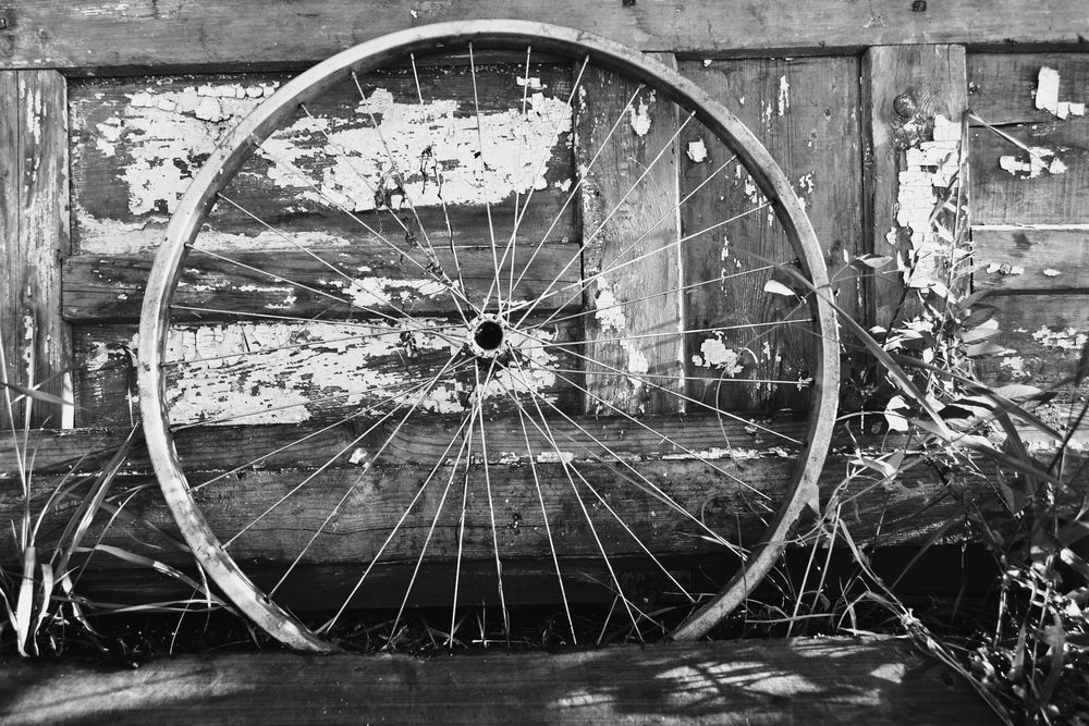 Обои для рабочего стола Велосипедное колесо облокачивается на стену деревянного дома
