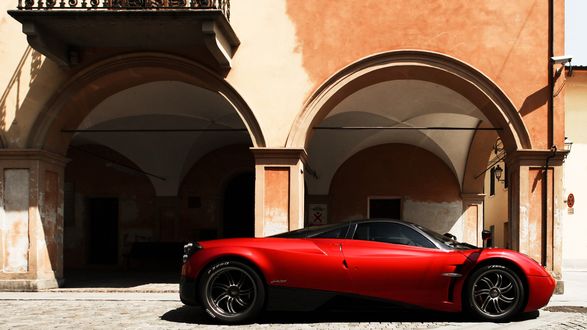 Обои на рабочий стол Автомобиль Pagani Huayra / Пагани Уайра в красно-черном исполнении припаркован под старым зданием с колоннами и арками