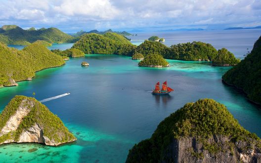 Обои на рабочий стол Парусник плывет по воде между скал, Индонезия / Indonesia