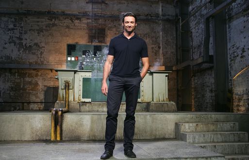 Обои на рабочий стол Актер Hugh Jackman / Хью Джекман стоит в заводском помещении, позади какой-то агрегат