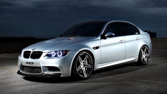 Обои на рабочий стол BMW стоит на дороге на фоне неба