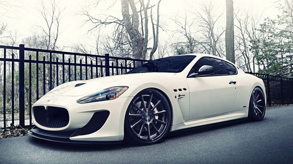Обои на рабочий стол Автомобиль Maserati GranTurismo MC 2013 / Мазерати Гран Турисмо ЭмСи 2013 года белого цвета рядом с металлической оградой в парке