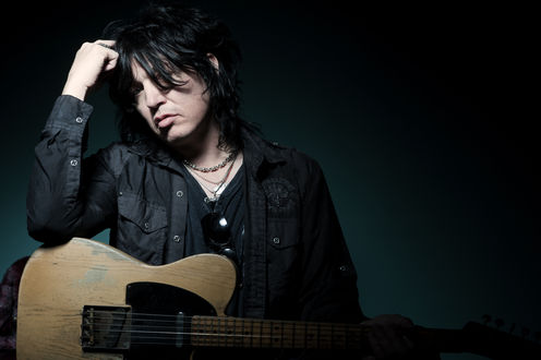 Обои на рабочий стол Американский музыкант, вокалист группы Cinderella / Золушка Tom Keifer / Том Кифер в черном с гитарой на темном фоне